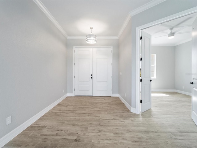 foyer entrance featuring light hardwood / wood-style flooring, ceiling fan, and crown molding