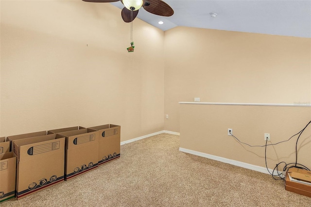 carpeted spare room featuring vaulted ceiling and ceiling fan