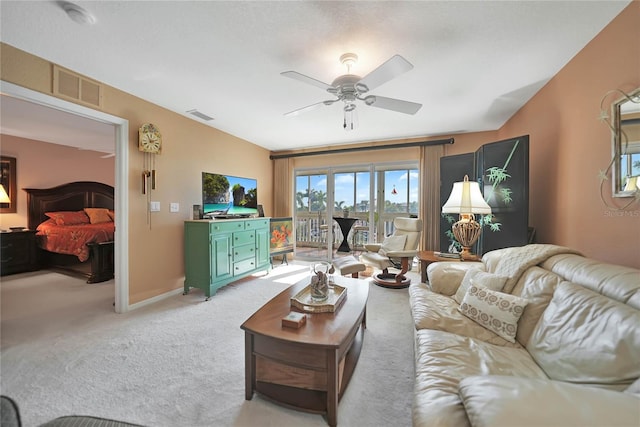 carpeted living room with ceiling fan and vaulted ceiling