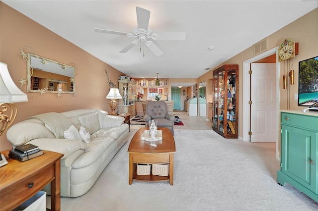 carpeted living room with ceiling fan