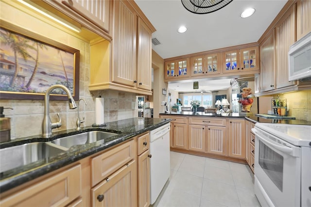 kitchen with white appliances, sink, decorative backsplash, dark stone countertops, and light tile patterned flooring