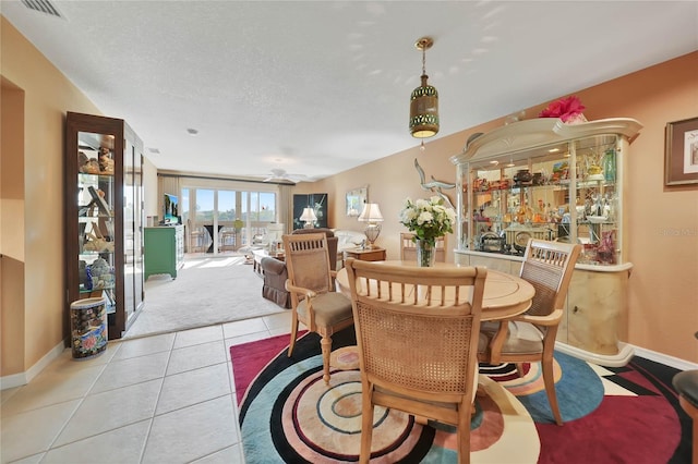 dining room with ceiling fan, light tile patterned flooring, and a textured ceiling