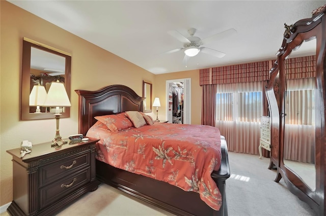 carpeted bedroom with a walk in closet, a closet, and ceiling fan