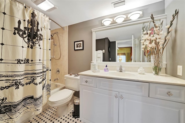 full bathroom with tile patterned floors, shower / bath combo with shower curtain, vanity, and toilet