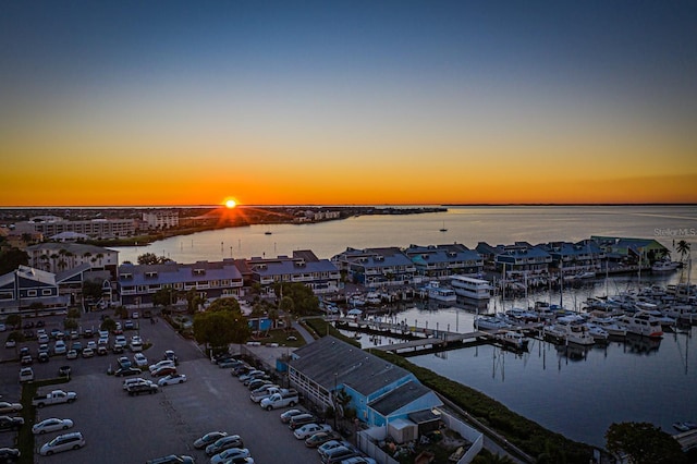 aerial view at dusk featuring a water view