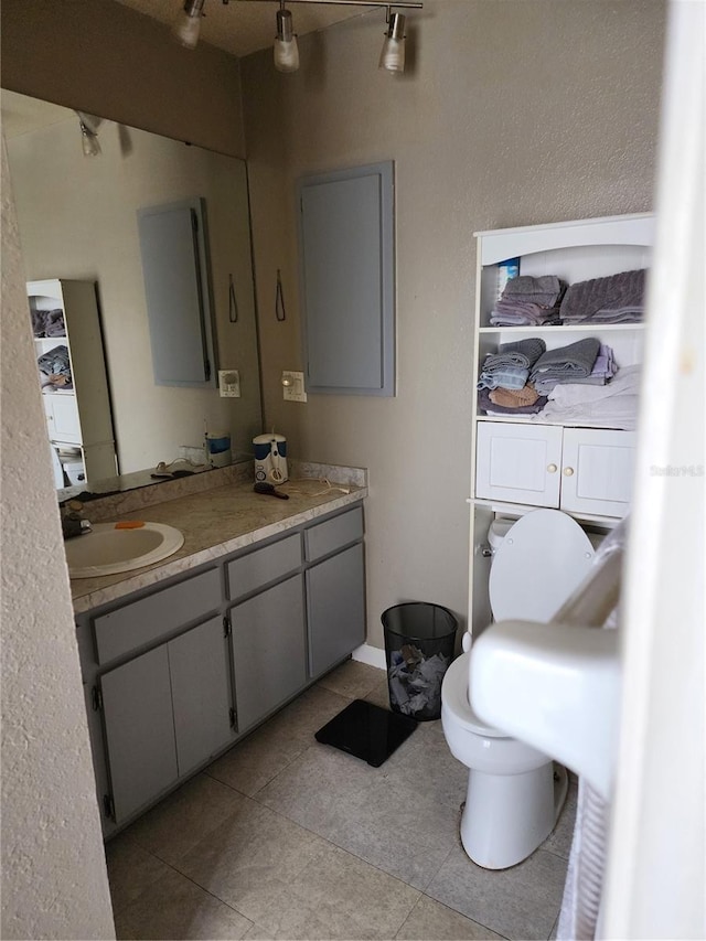 bathroom featuring toilet, vanity, and tile patterned flooring