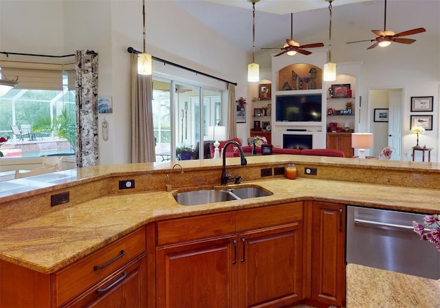 kitchen with pendant lighting, light stone counters, sink, and high vaulted ceiling