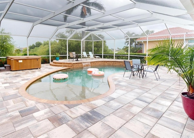 view of swimming pool featuring glass enclosure, a patio, and a hot tub