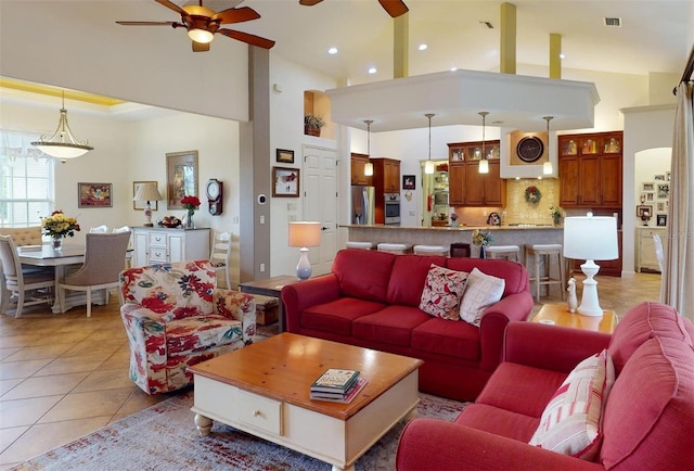 tiled living room featuring ceiling fan and high vaulted ceiling