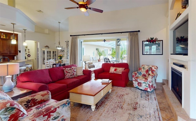 living room with ceiling fan, light tile patterned floors, and high vaulted ceiling