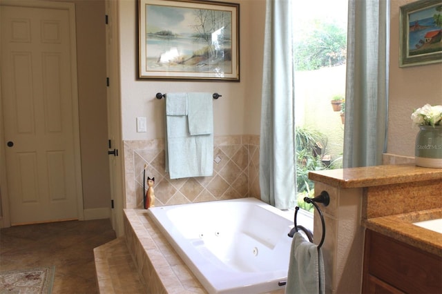 bathroom with tile patterned floors, tiled bath, and vanity