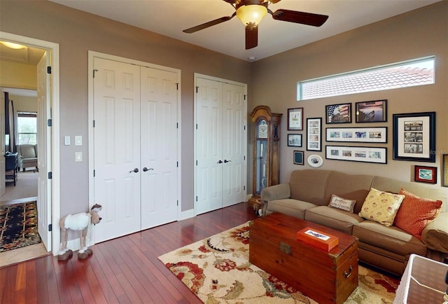 living room with ceiling fan and dark hardwood / wood-style flooring