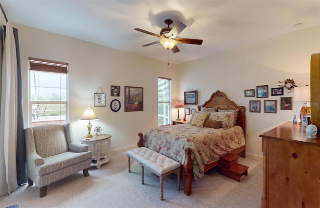 carpeted bedroom with ceiling fan and multiple windows