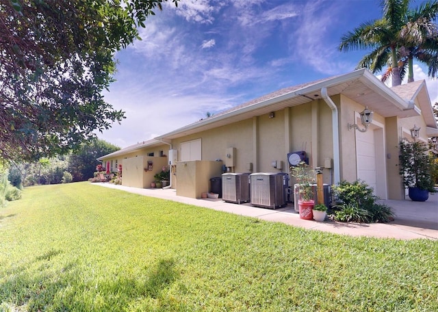 rear view of property with a yard and central air condition unit