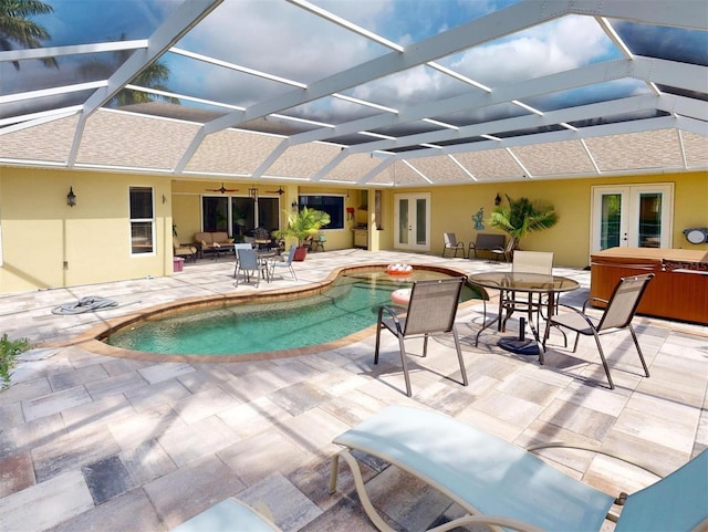 view of swimming pool with a lanai, a patio area, french doors, and a hot tub