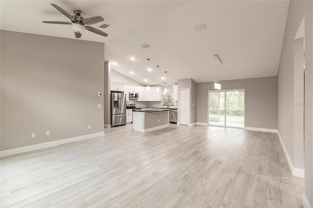 unfurnished living room with light wood-type flooring, ceiling fan, and lofted ceiling