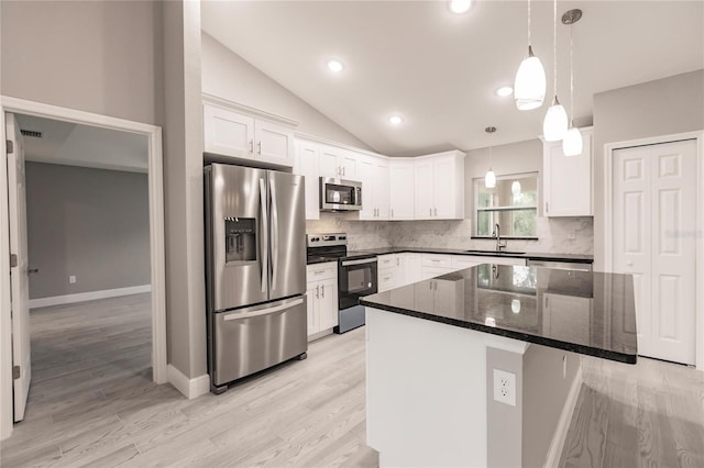 kitchen featuring white cabinets, sink, hanging light fixtures, a kitchen island, and stainless steel appliances