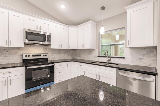 kitchen featuring white cabinetry, sink, vaulted ceiling, and appliances with stainless steel finishes