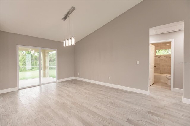 unfurnished room featuring light wood-type flooring and lofted ceiling