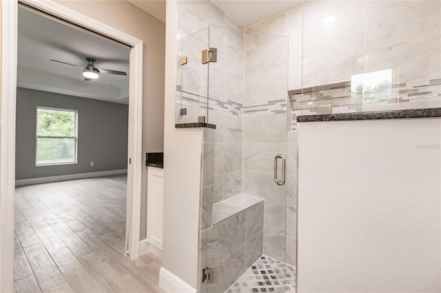 bathroom featuring wood-type flooring, walk in shower, and ceiling fan