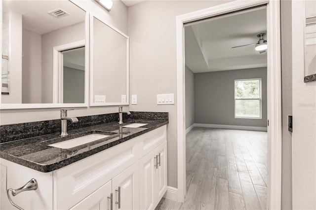 bathroom featuring wood-type flooring, vanity, and ceiling fan