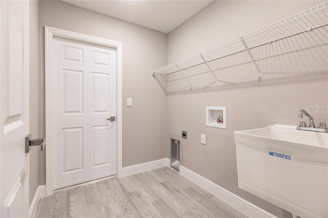 laundry room with washer hookup, electric dryer hookup, light wood-type flooring, and sink