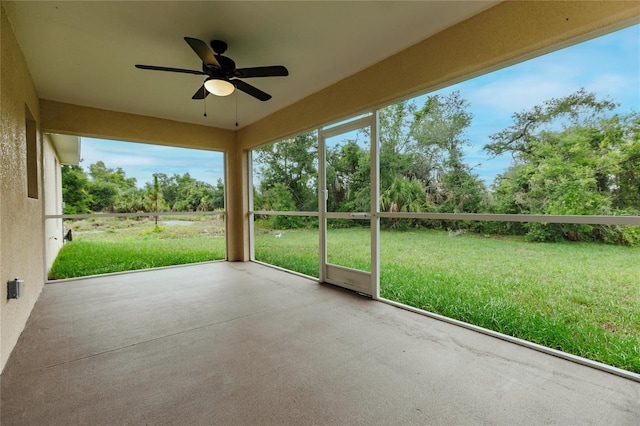 unfurnished sunroom with ceiling fan