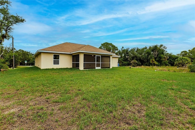 back of property featuring a sunroom and a yard