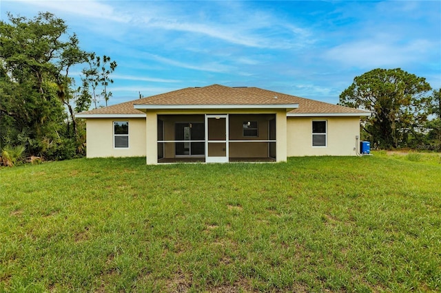 rear view of property with a sunroom and a yard