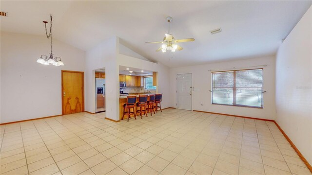 kitchen featuring light tile patterned floors, ceiling fan with notable chandelier, stainless steel appliances, and a wealth of natural light