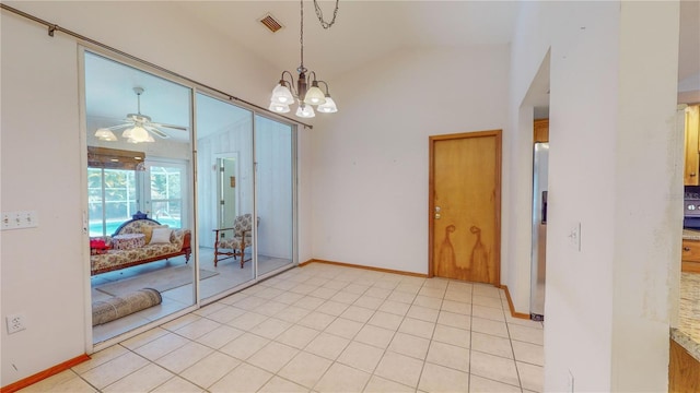 tiled empty room featuring ceiling fan with notable chandelier and vaulted ceiling