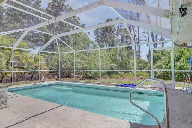 view of swimming pool with glass enclosure and a patio