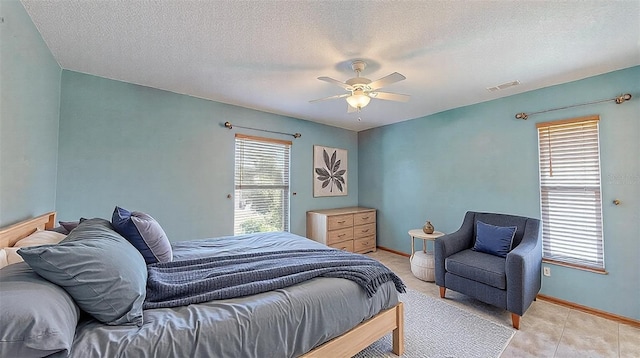 bedroom with ceiling fan and a textured ceiling