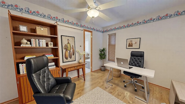 home office featuring light hardwood / wood-style flooring and ceiling fan