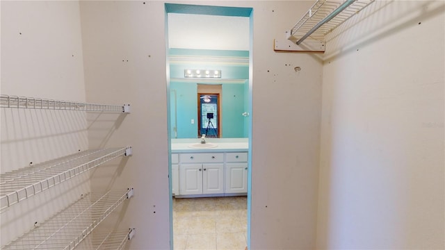 spacious closet featuring light tile patterned floors and sink