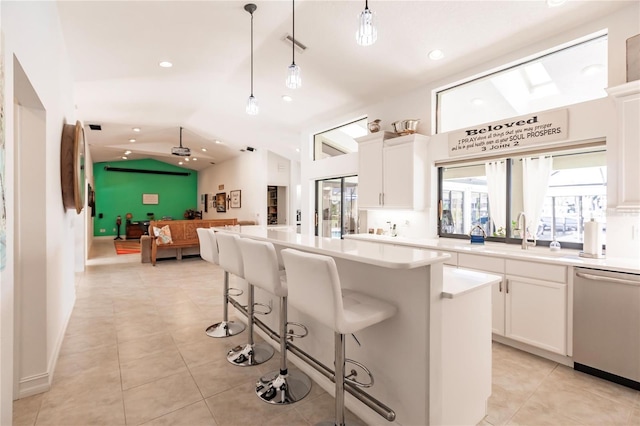 kitchen featuring pendant lighting, white cabinets, sink, stainless steel dishwasher, and a kitchen island