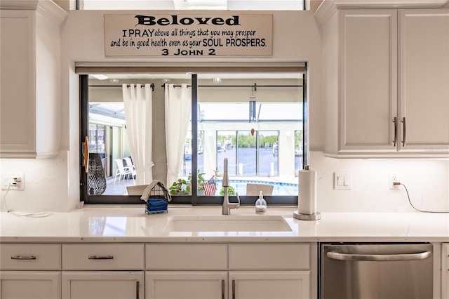 kitchen featuring dishwasher, white cabinetry, and sink