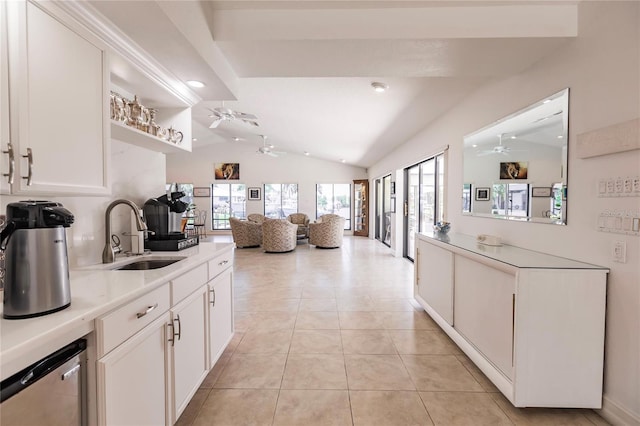 kitchen with vaulted ceiling, sink, light tile patterned floors, dishwasher, and white cabinetry