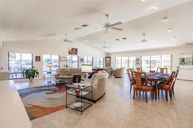 living room featuring ceiling fan, light tile patterned floors, a textured ceiling, and vaulted ceiling