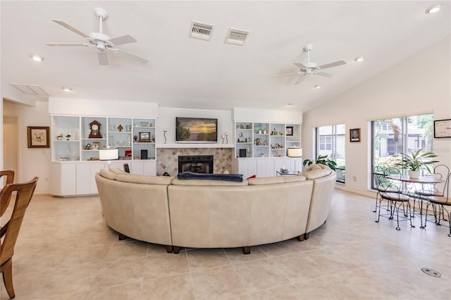 tiled living room with ceiling fan and lofted ceiling