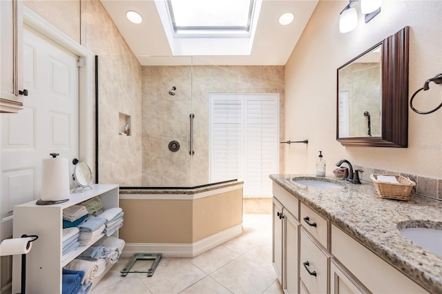 bathroom with tile patterned floors, vanity, a tile shower, and a skylight