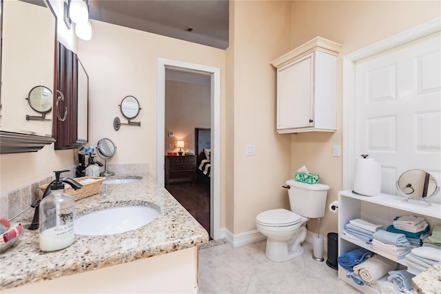 bathroom with tile patterned flooring, vanity, and toilet