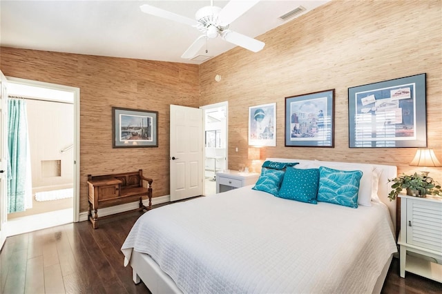 bedroom featuring dark hardwood / wood-style flooring, ensuite bathroom, vaulted ceiling, and ceiling fan