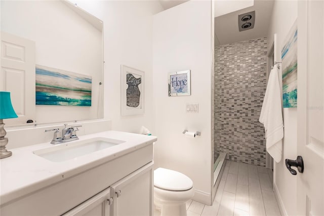 bathroom with vanity, toilet, and a shower