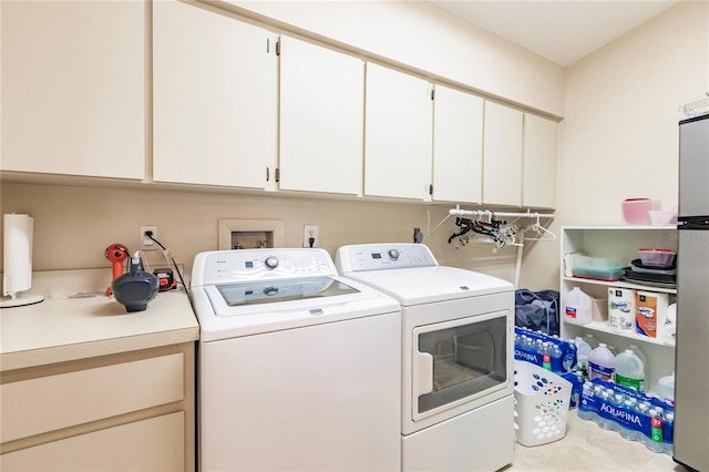 clothes washing area featuring cabinets and separate washer and dryer