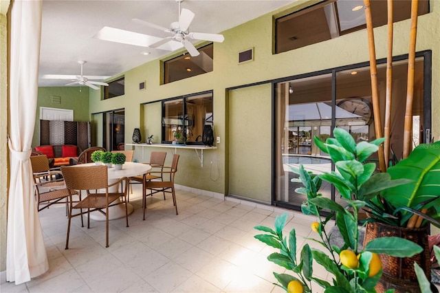 sunroom / solarium featuring vaulted ceiling with skylight and ceiling fan