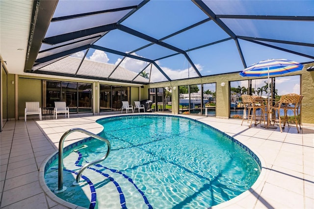 view of swimming pool with a patio area and a lanai