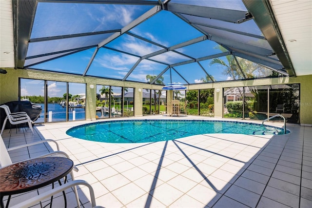 view of swimming pool featuring a lanai, a patio area, and a water view