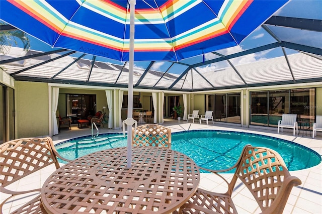 view of swimming pool with glass enclosure and a patio area