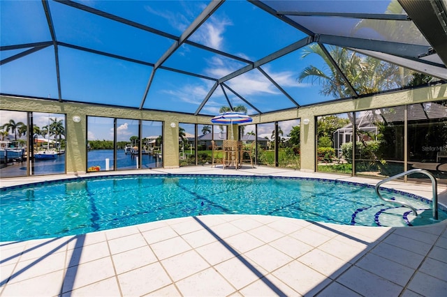 view of pool with a lanai, a patio area, and a water view